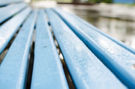 Close up of wet blue bench under the rainの写真素材