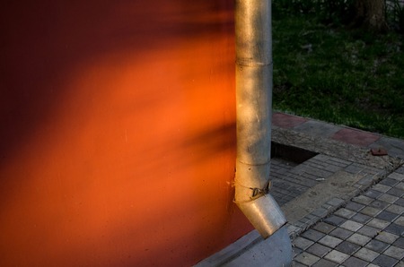 Water running pipe on the street during the sunsetの写真素材