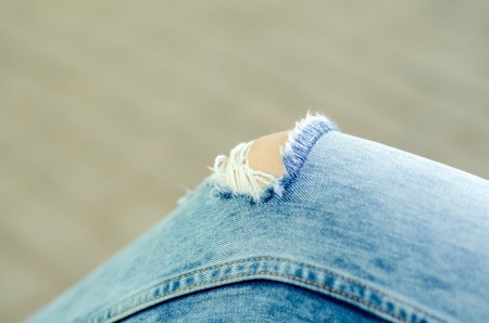 Close up of hole in blue girl's jeansの写真素材