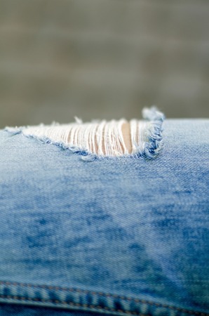 Close up of hole in blue girl's jeansの写真素材