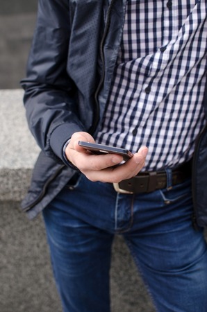 Young man using his phone on the street