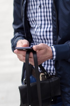 Young man using his phone on the streetの写真素材