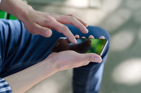 Young man using his phone on the street