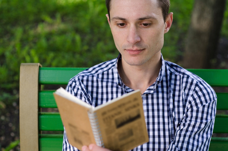 Young man making notes in the notepad on the streetの写真素材