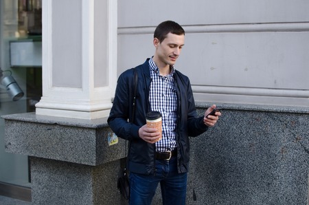 Young man using his phone on the street