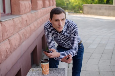 Young man smoking cigarette on the streetの写真素材