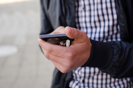 Young man using his phone on the streetの写真素材