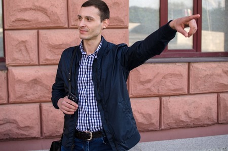 Young man showing direction to person on the streetの写真素材