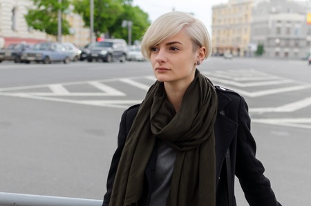 Young blonde girl walking on the city streetsの写真素材