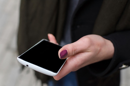 Young girl using her phone in the cityの写真素材