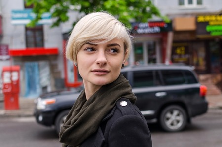 Young blonde girl walking on the city streetsの写真素材