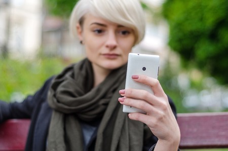 Young blonde girl making selfie in the cityの写真素材