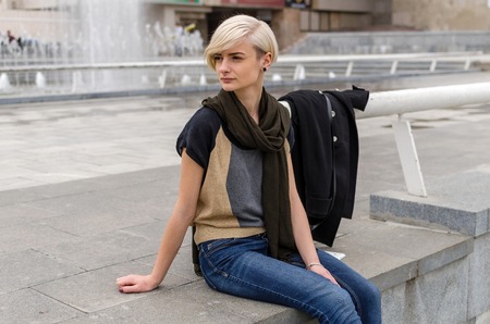 Young blonde girl walking on the city streetsの写真素材