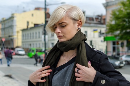 Young blonde girl walking on the city streetsの写真素材