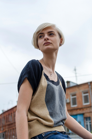 Young blonde girl walking on the city streetsの写真素材