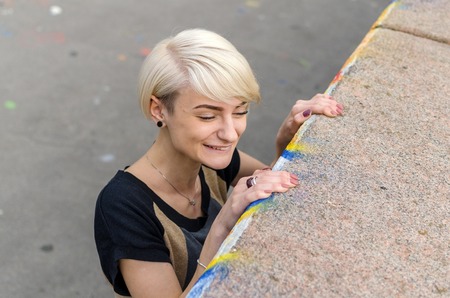 Young blonde girl walking on the city streetsの写真素材