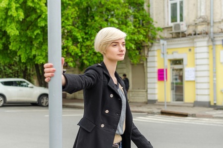 Young blonde girl walking on the city streetsの写真素材