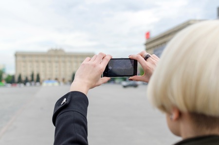 Young blonde girl making selfie in the city