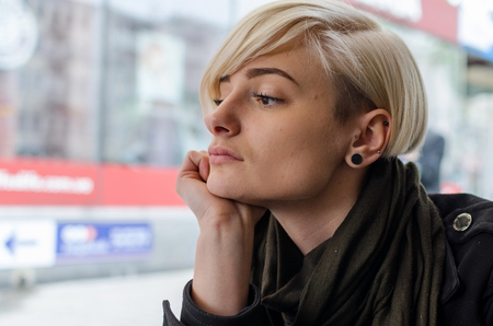 Sad girl sitting on the city street