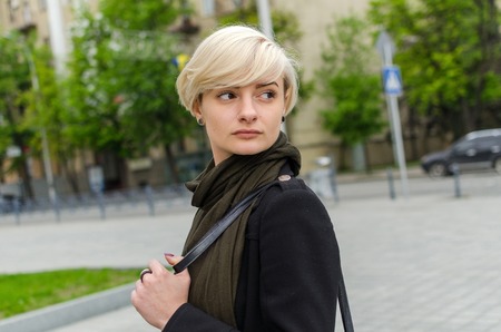Young blonde girl walking on the city streetsの写真素材
