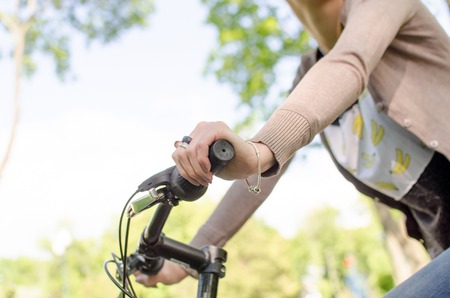 Young beautiful girl riding a white bicycle in the parkの写真素材