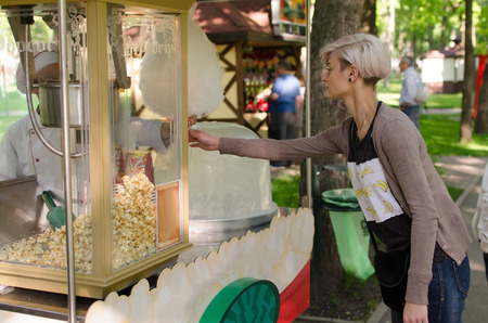 Young beautiful girl with cotton candy in the parkの写真素材