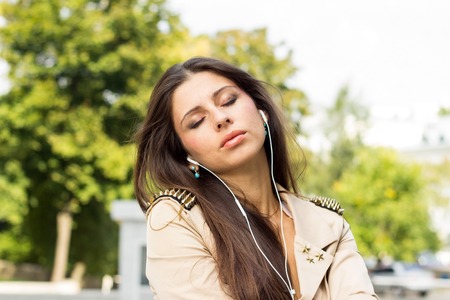 Young woman listenign to music on the streetの写真素材