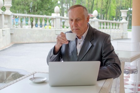 Aged man is using laptop in the parkの写真素材