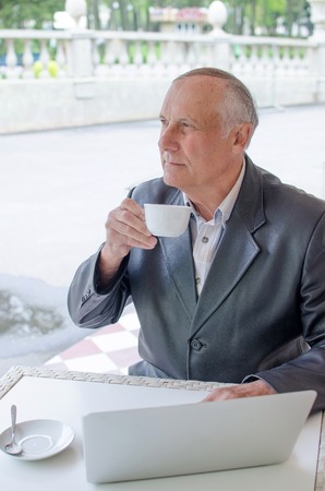Aged man is using laptop in the parkの写真素材