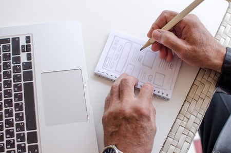 Aged man is making notes in the notebook in the parkの写真素材