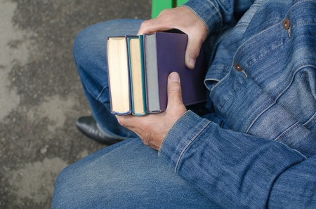 Aged man is holding books in his handsの写真素材