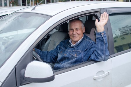 Aged man is sitting in the carの写真素材