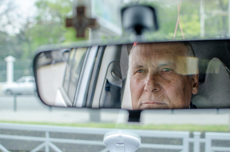 Aged man is sitting in the carの写真素材