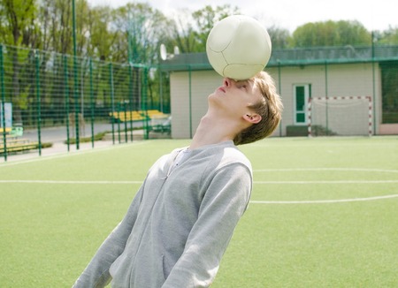 Young man making football freestyle on the fieldの写真素材