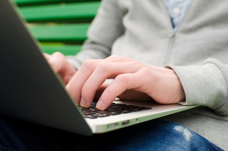 Young man using his laptop in the parkの写真素材