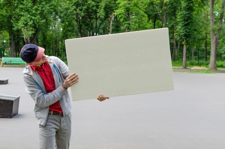 Man with white billboard in park 
natureの写真素材