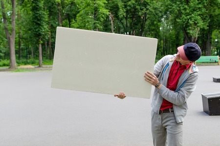 Man with white billboard in park 
natureの写真素材