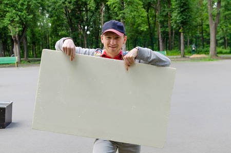 Man with white billboard in park natureの写真素材
