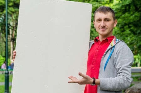 Man with white billboard in park natureの写真素材
