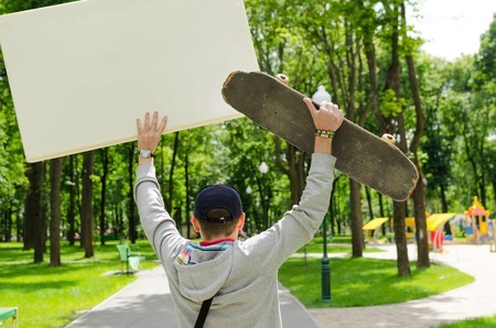 Young man with skateboard in the parkの写真素材