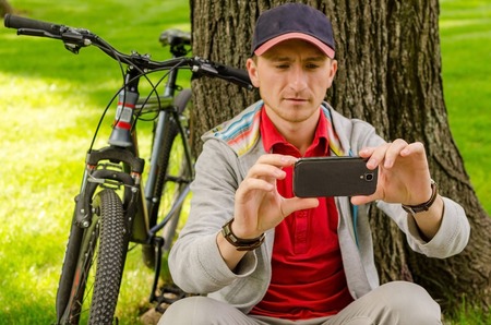 Young man with the bicycle in the parkの写真素材