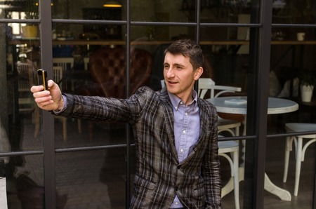 Young man is making selfie on his phoneの写真素材