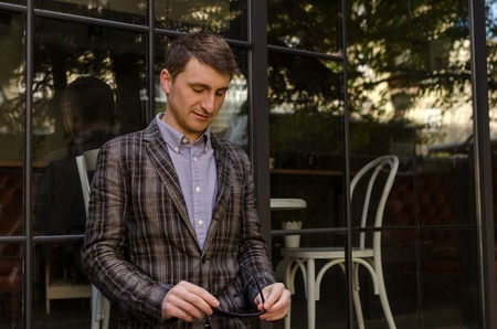 Young man in suit looking at sunglassesの写真素材