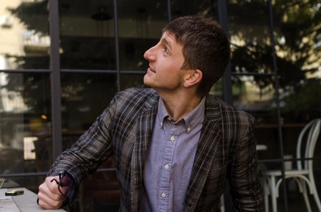 Young man in grey suit with sunglasses is looking upの写真素材