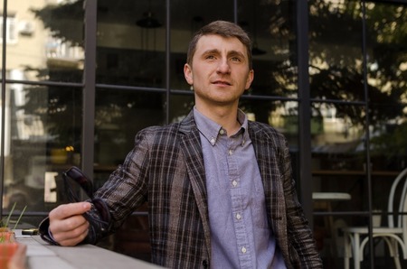 Photo of young man in grey suit and blue shirt looking upの写真素材