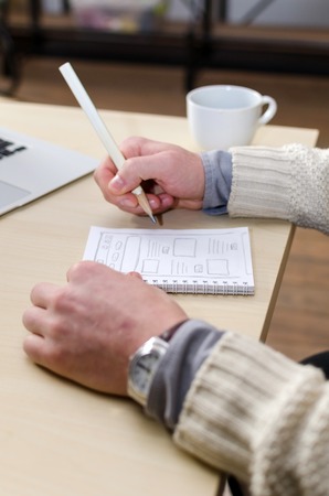 Man with a cup of coffee drawing smthの写真素材