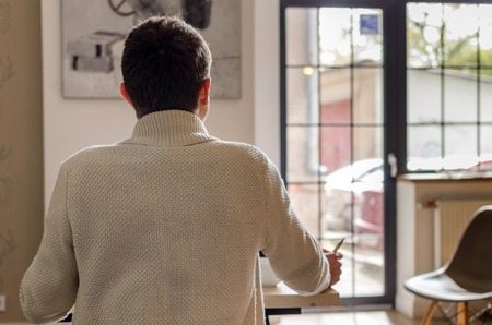 Photo of man from the backside sitting at the tableの写真素材