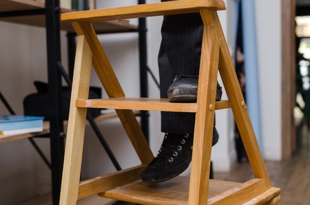 Man climbing the wooden stairs in the libraryの写真素材