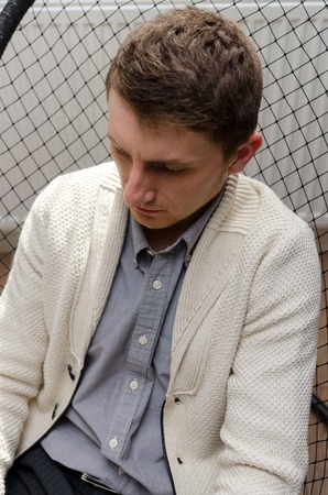 Close-up pfoto of young man sitting in armchair