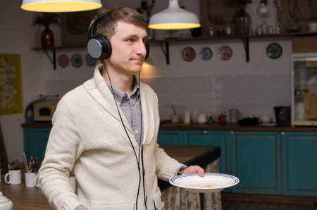 Close-up photo of man enjoying music and holding a plateの写真素材